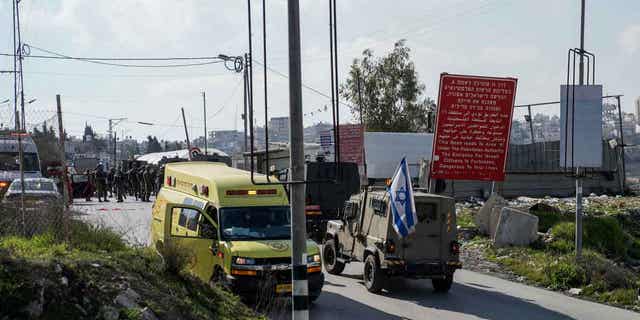 Israeli security forces examine the scene of a shooting in the West Bank town of Halhul, on Jan. 17, 2023. The Palestinian Health Ministry said a Palestinian was shot and killed by Israeli forces in Halhul, north of the West Bank city of Hebron. 