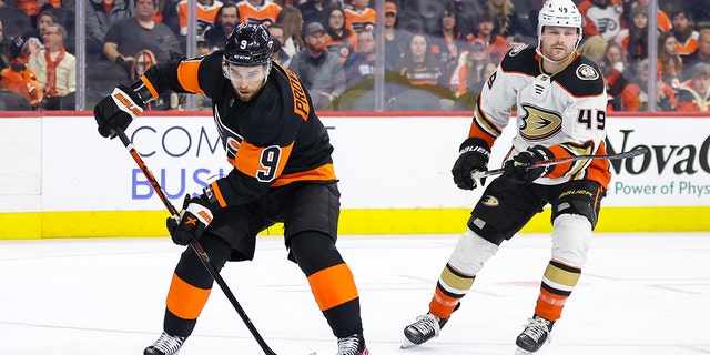 Ivan Provorov de los Flyers patina con el disco y supera a Max Jones de los Anaheim Ducks el 17 de enero de 2023 en Filadelfia.
