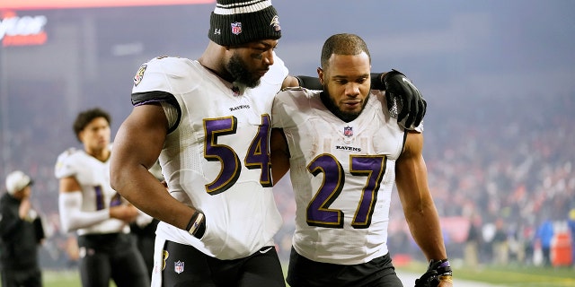 El apoyador de los Baltimore Ravens, Tyus Bowser, a la izquierda, y el corredor JK Dobbins salen del campo luego de su derrota ante los Bengals en el juego de playoffs por el comodín en Cincinnati, el domingo 15 de enero de 2023.