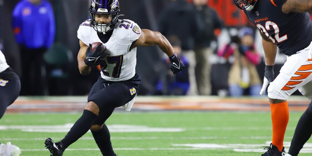 El corredor de los Baltimore Ravens, JK Dobbins, se enfrenta a los Bengals el 15 de enero de 2023 en el Paycor Stadium de Cincinnati.