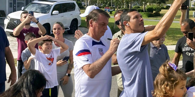 FILE: Former Brazil President Jair Bolsonaro, center, meets with supporters outside a vacation home where he is staying near Orlando, Fla., on Wednesday, Jan. 4, 2023.