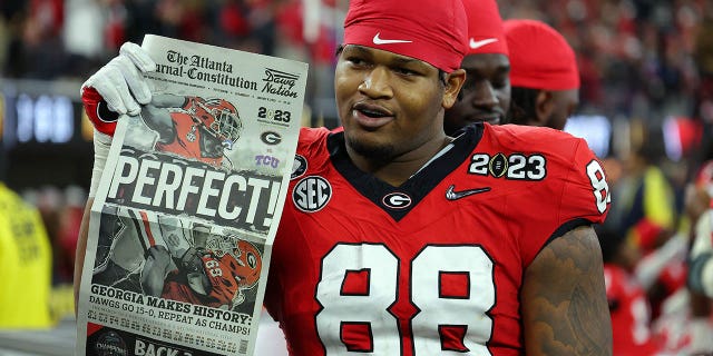 Jalen Carter, #88 of the Georgia Bulldogs, celebrates by reading a newspaper, "Perfect!" after defeating the TCU Horned Frogs in the College Football Playoff National Championship game at SoFi Stadium on January 9, 2023, in Inglewood, California.  Georgia defeated TCU 65-7.