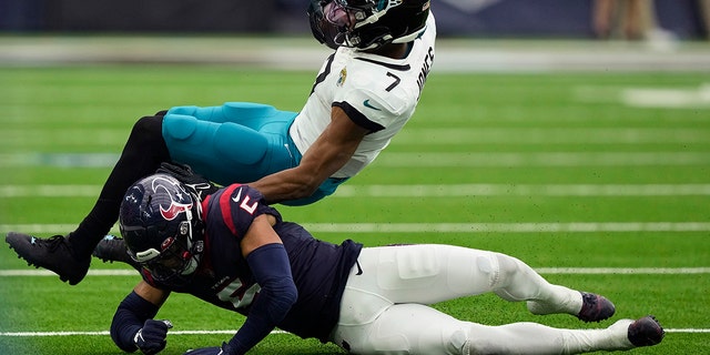 El receptor abierto de los Jacksonville Jaguars, Zay Jones, es golpeado por el profundo de los Texans, Jalen Pitre, luego de hacer una atrapada en Houston, el domingo 1 de enero de 2023.