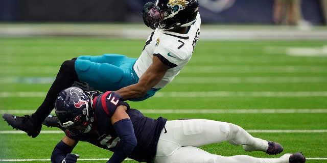 El receptor abierto de los Jacksonville Jaguars, Zay Jones, es golpeado por el profundo de los Texans, Jalen Pitre, luego de hacer una atrapada en Houston, el domingo 1 de enero de 2023.