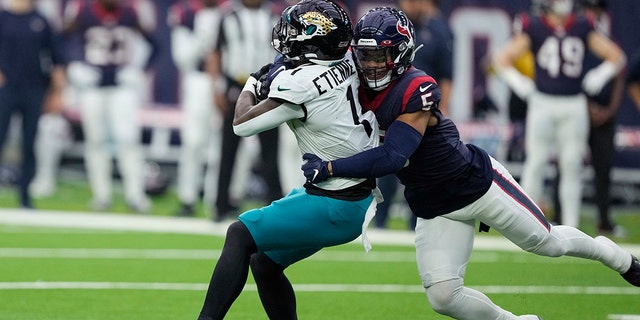 Jacksonville Jaguars running back Travis Etienne Jr. is hit by Texans safety Jalen Pitre in Houston, Sunday, Jan. 1, 2023.