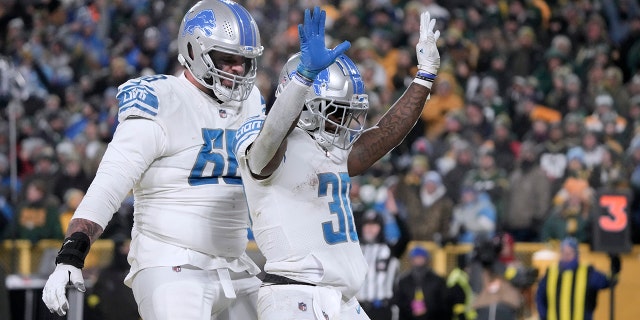 El corredor de los Detroit Lions, Jamaal Williams, n.º 30, celebra después de anotar mientras su compañero Taylor Decker, n.º 68, observa durante la segunda mitad de un partido de fútbol americano de la NFL el domingo 8 de enero de 2023 en Green Bay, Wisconsin.