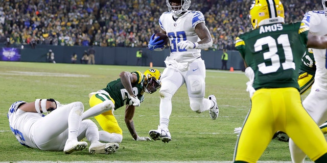 Detroit Lions running back Jamaal Williams, #30, scores on a touchdown run during the second half of an NFL football game against the Green Bay Packers Sunday, Jan. 8, 2023, in Green Bay, Wisconsin.