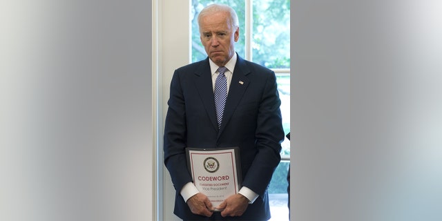 Vice President Joe Biden holds a classified document in the Oval Office on Sept. 30, 2013.