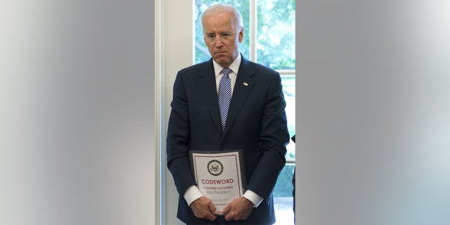 Vice President Joe Biden holds a classified document in the Oval Office on Sept.  30, 2013.