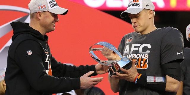 Cincinnati Bengals quarterback Joe Burrow receives the Lamar Hunt trophy from head coach Zac Taylor after the AFC Championship game against the Chiefs on Jan 30, 2022, at Arrowhead Stadium in Kansas City, Missouri.