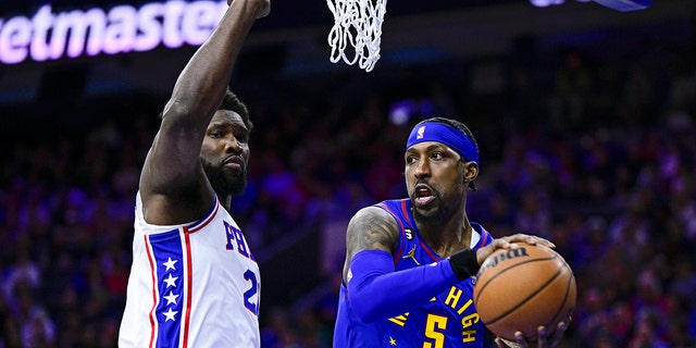 Kentavious Caldwell-Pope of the Denver Nuggets passes the ball as Joel Embiid of the Philadelphia 76ers defends, Saturday, Jan. 28, 2023, in Philadelphia.