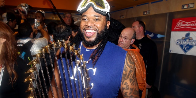 Johnny Cueto de los Kansas City Royals, #47, celebra con el trofeo del comisionado en el vestuario después de ganar el Juego 5 de la Serie Mundial 2015 7-2 sobre los Mets de Nueva York en el Citi Field el domingo 1 de noviembre de 2015 en el vecindario de Queens de Nueva York