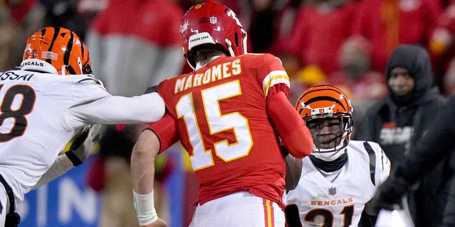 Cincinnati Bengals defensive end Joseph Ossai, left, is called for roughing the passer as Chiefs quarterback Patrick Mahomes is hit out of bounds during the AFC championship Game, Sunday, Jan. 29, 2023, at GEHA Field at Arrowhead Stadium in Kansas City, Missouri.