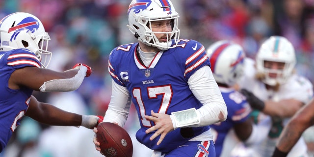 Le quart-arrière des Buffalo Bills Josh Allen (17 ans) dirige un jeu au cours de la seconde moitié d'un match de football des séries éliminatoires de la NFL contre les Dolphins de Miami, le dimanche 15 janvier 2023, à Orchard Park, Nueva York.