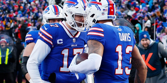 Buffalo Bills wide receiver Gabe Davis (13), right, is congratulated by quarterback Josh Allen after his touchdown catch during the second half of an NFL Wild Card Playoff football game against the Miami Dolphins, on Sunday, January 15, 2023, in Orchard.  Park, New York.