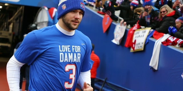 Quarterback Josh Allen of the Buffalo Bills jogs onto the field wearing a Damar Hamlin shirt before the New England Patriots game on Jan. 8, 2023, in Orchard Park, New York.