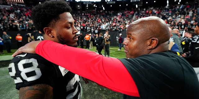 Josh Jacobs of the Raiders and Eric Bieniemy of the Kansas City Chiefs meet after their game at Allegiant Stadium on Jan. 7, 2023, in Las Vegas.