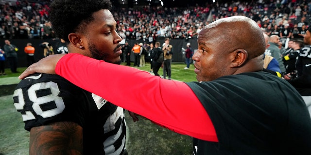 Josh Jacobs of the Raiders and Eric Bieniemy of the Kansas City Chiefs meet after their game at Allegiant Stadium on Jan. 7, 2023, in Las Vegas.