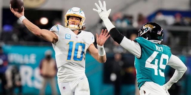 El mariscal de campo de los Chargers de Los Ángeles, Justin Herbert, lanza un pase contra los Jaguars de Jacksonville en la primera mitad de un partido de playoffs de comodines, el sábado 14 de enero de 2023 en Jacksonville, Florida.