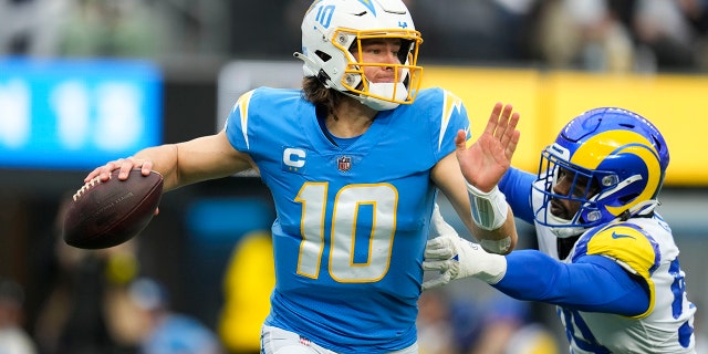 El mariscal de campo de Los Angeles Chargers, Justin Herbert (10), busca lanzar un pase durante la primera mitad de un partido de fútbol americano de la NFL contra Los Angeles Rams el domingo 1 de enero de 2023 en Inglewood, California. 