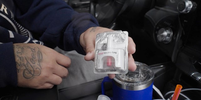 Frank Rodriguez holds out a dose of Narcan. The addict-turned-activist keeps the drug in his glove compartment and has it prepared whenever he enters Philadelphia.