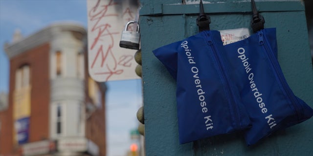 Opioid overdose kits containing naloxone — commonly referred to by its brand name, Narcan — hang from a metal support in Kensington. The Philadelphia neighborhood is widely known as an open-air drug market.