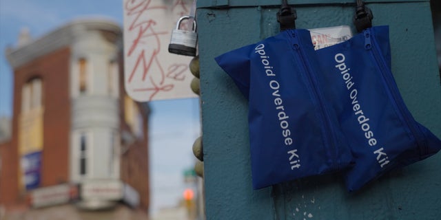 Opioid overdose kits containing naloxone — commonly referred to by its brand name, Narcan — hang from a metal support in Kensington. The Philadelphia neighborhood is widely known as an open-air drug market.