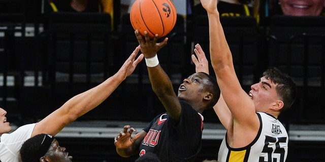 Northern Illinois Huskies guard Kaleb Thornton, center, and forward Chris Johnson, #0, and guard Tyler Cochran, #23, and Iowa Hawkeyes forward Jack Nunge, #2, and center Luka Garza, #55, and forward Patrick McCaffery, #22, in action at the Carver-Hawkeye Arena in Iowa City, Iowa, Dec. 13, 2020.
