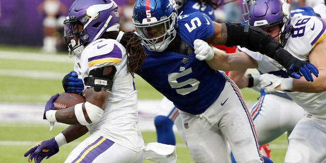 El corredor de los Vikings, Dalvin Cook, se aleja del ala defensiva de los New York Giants, Kayvon Thibodeaux, el 24 de diciembre de 2022 en Minneapolis.