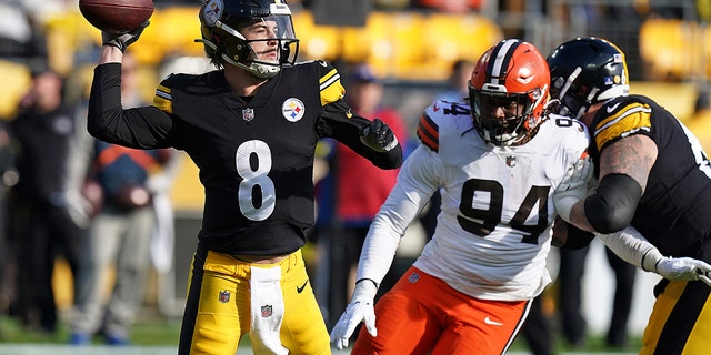 Pittsburgh Steelers quarterback Kenny Pickett (8) searches for a pass as he is pressured by Cleveland Browns defensive end Alex Wright (94) during the first half of a football game in the NFL in Pittsburgh on Sunday, January 8, 2023. 