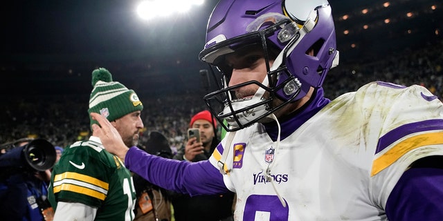 Minnesota Vikings quarterback Kirk Cousins (8) walks off the field ahead of Green Bay Packers quarterback Aaron Rodgers, left, after an NFL football game, Sunday, Jan. 1, 2023, in Green Bay, Wis.