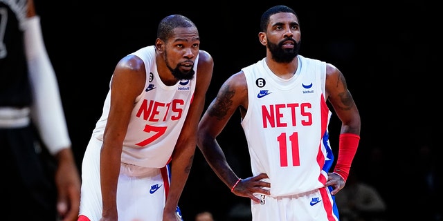 Brooklyn Nets' Kevin Durant (7) talks to Kyrie Irving (11) during the second half of an NBA basketball game against the San Antonio Spurs, Monday, Jan. 2, 2023, in New York.
