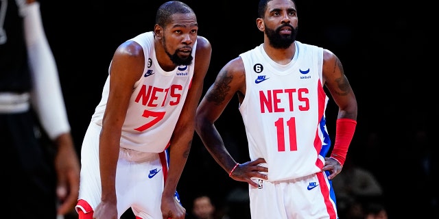 Brooklyn Nets' Kevin Durant (7) talks with Kyrie Irving (11) during the second half of an NBA basketball game against the San Antonio Spurs, Monday, Jan. 2, 2023, in New York.