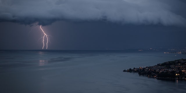 Lightning illuminates Lake Geneva next to the village of Cully during a storm seen from Chexbres, western Switzerland, on August 16, 2020. 