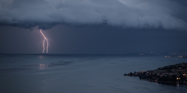 Lightning illuminates Lake Geneva next to the village of Cully during a storm seen from Chexbres, western Switzerland, on August 16, 2020.