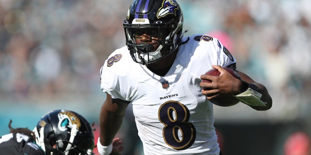 Lamar Jackson #8 of the Baltimore Ravens carries the ball defended by Rayshawn Jenkins #2 of the Jacksonville Jaguars during the first half at TIAA Bank Field on November 27, 2022 in Jacksonville, Florida.