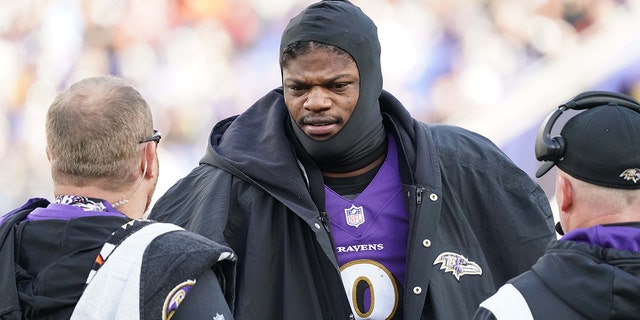 Baltimore Ravens quarterback Lamar Jackson (8) praat met teamstaf aan de zijlijn in het tweede kwartaal nadat hij op 4 december 2022 werd ontslagen tegen de Denver Broncos in Baltimore.