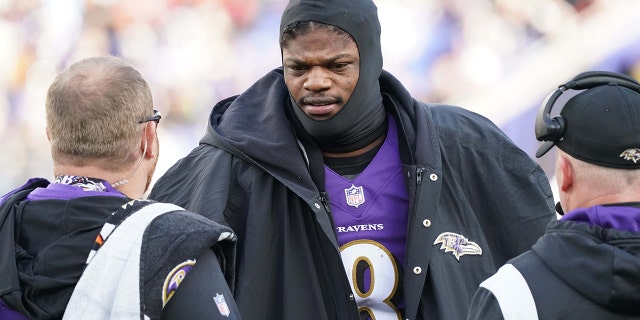 Baltimore Ravens quarterback Lamar Jackson (8) talks with team staff on the sideline in the second quarter after being sacked against the Denver Broncos in Baltimore on Dec. 4, 2022.