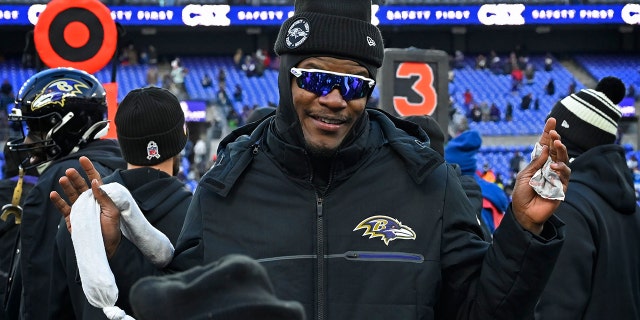 Baltimore Ravens quarterback Lamar Jackson stands on the sidelines cheering on his teammates during the Ravens' 17-9 win over the Atlanta Falcons on Saturday, December 24, 2022.