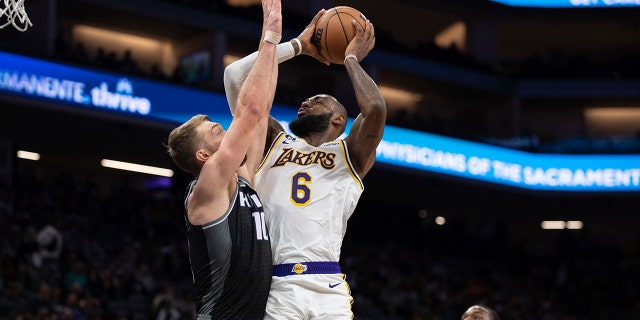 Kings forward Domantas Sabonis defends against Los Angeles Lakers forward LeBron James in Sacramento, California, Saturday, Jan. 7, 2023.
