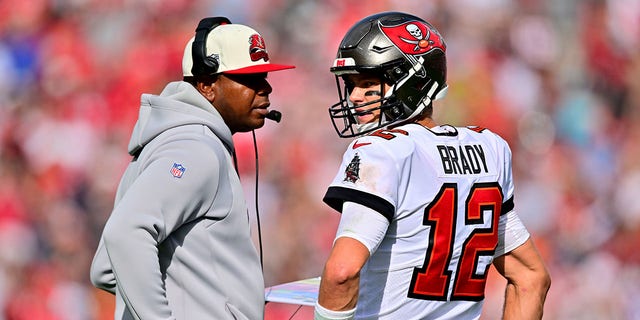 Tom Brady (12) of the Tampa Bay Buccaneers talks with offensive coordinator Byron Leftwich during the second quarter against the Carolina Panthers at Raymond James Stadium Jan. 1, 2023, in Tampa, Fla.