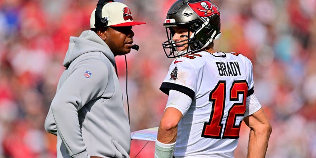 Tom Brady (12) of the Tampa Bay Buccaneers talks with offensive coordinator Byron Leftwich during the second quarter against the Carolina Panthers at Raymond James Stadium Jan. 1, 2023, in Tampa, Fla.