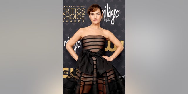 Lily James wore a sheer strapless dress with a massive black bow tied in the front.