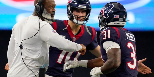 Dameon Pierce, #31 of the Houston Texans, celebrates with head coach Lovie Smith of the Houston Texans after scoring a touchdown in the first half at AT&amp;T Stadium on Dec. 11, 2022 in Arlington, Texas.