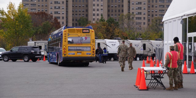 Migrants board MTA buses to be transported to a Hotel after NYC Mayor Adams announced the temporary housing unit would be closed indefinitely, Nov. 15, 2022.