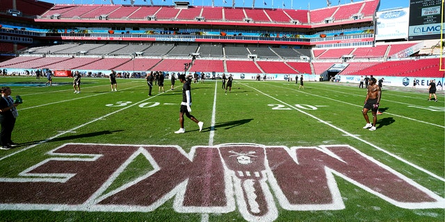 Mississippi State players warm up near a painting honoring "Mike" – former head coach Mike Leach – before the ReliaQuest Bowl against Illinois Monday, Jan. 2, 2023, in Tampa, Florida.