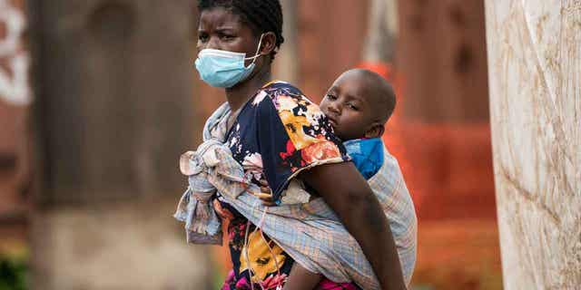 A child with cholera is being carried by his mother in central Malawi, on Jan. 11, 2023. 