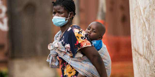 A child with cholera is being carried by his mother in central Malawi, on Jan. 11, 2023. 