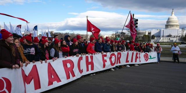 Dengan US Capitol sebagai latar belakang, demonstran pro-kehidupan berbaris menuju Mahkamah Agung AS selama March for Life, Jumat, 20 Januari 2023, di Washington. 