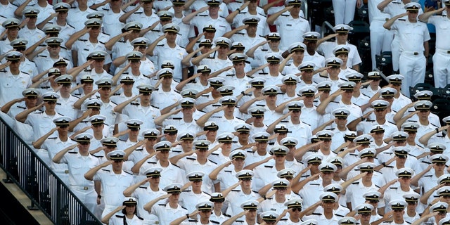 Midshipmen from the United States Merchant Marine Academy salute during the national anthem before a game at Citi Field on August 23, 2017 in New York City.